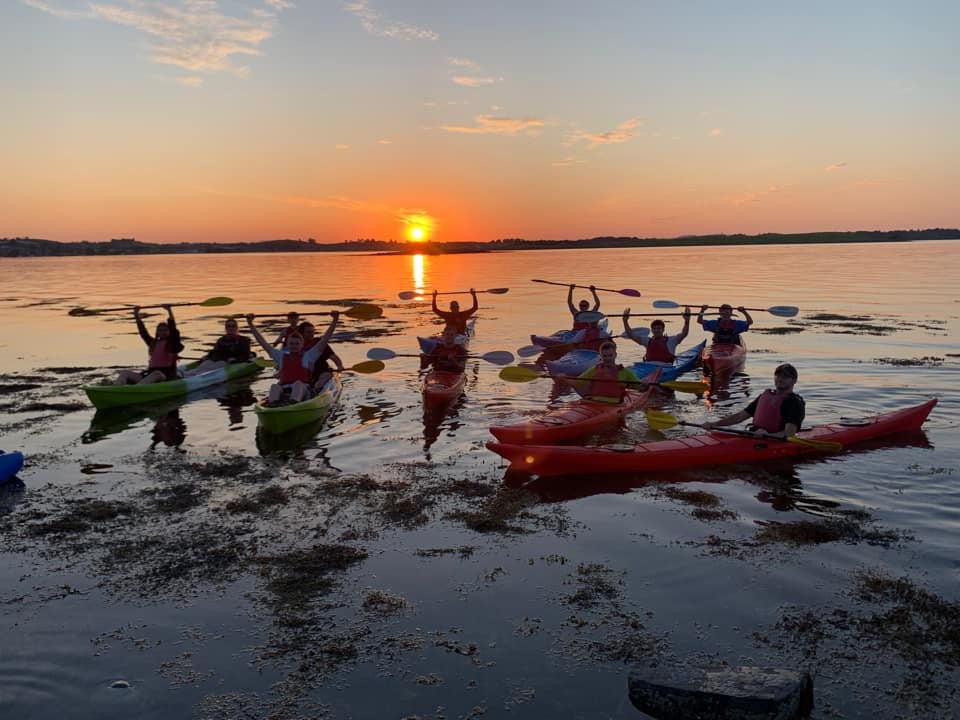 Kayak Group Paddles Raised Sunset