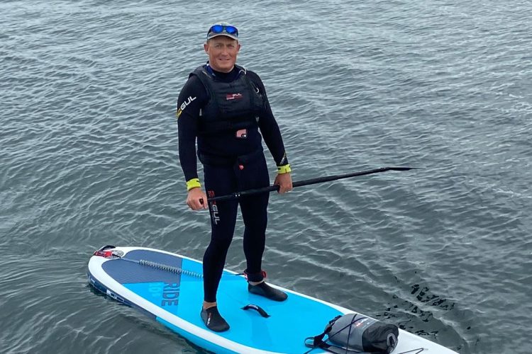 Director Rory Martin In Wetsuit On Paddle Board